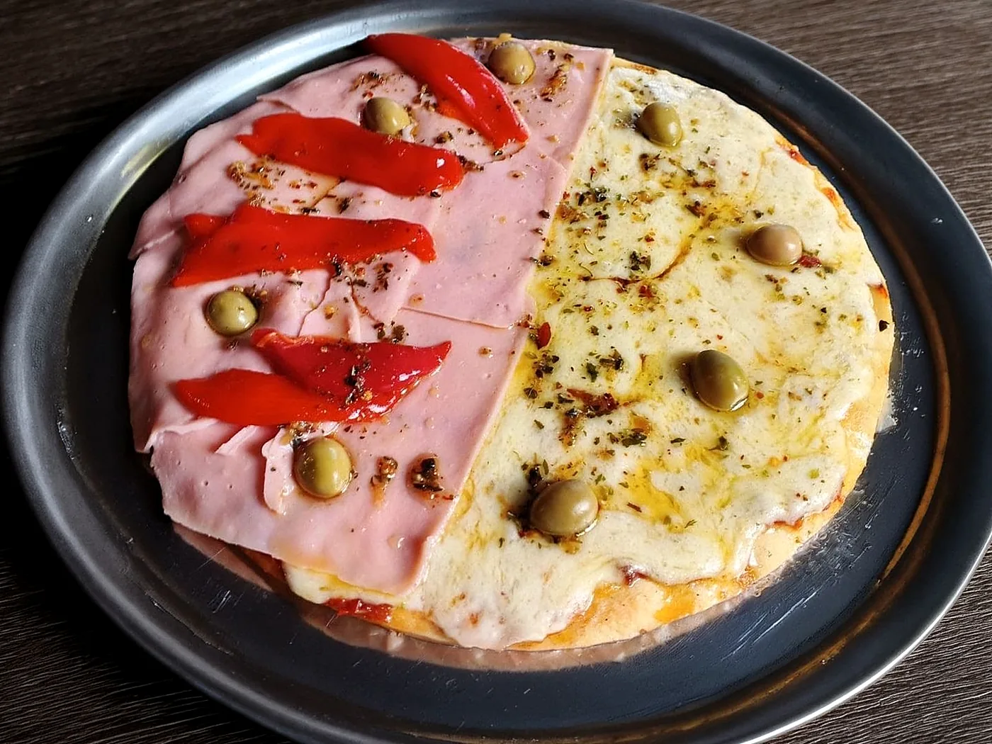 Pizza mitad muzzarella, mitad jamón y morrón